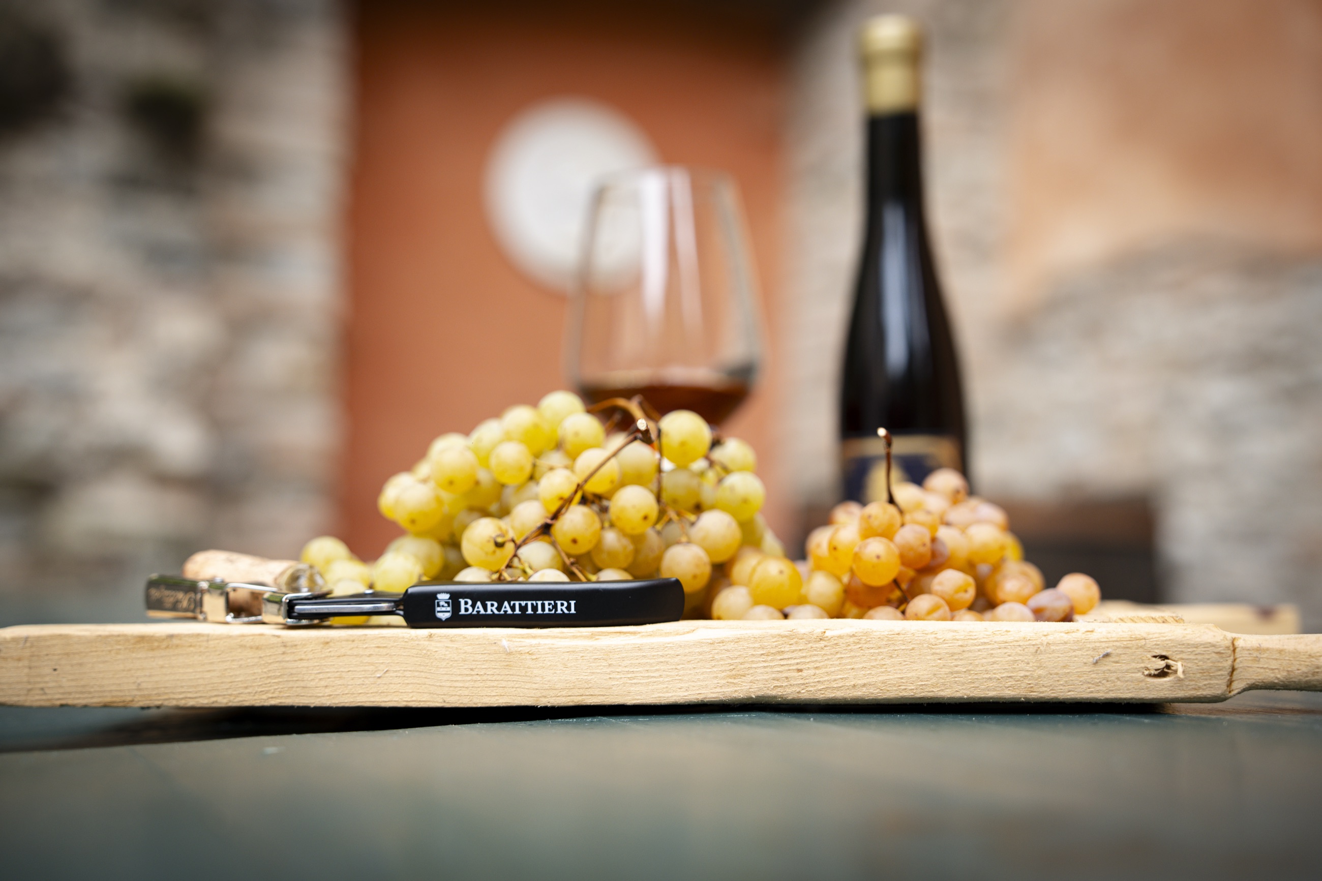 Uve Malvasia appena raccolte con calice di Vin Santo nel cortile della villa