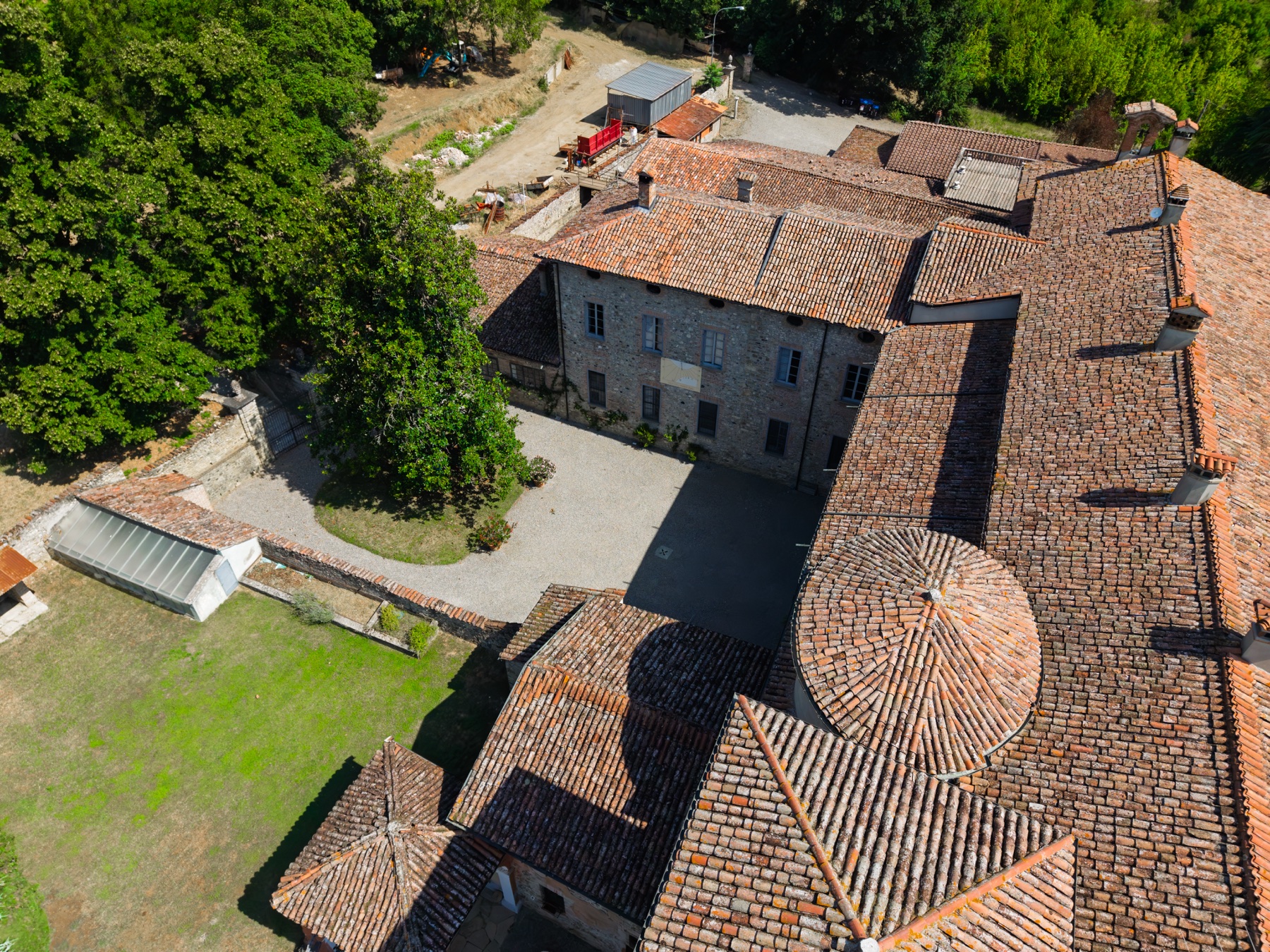 I tetti e la corte interna di Villa Barattieri visti dall'alto in estate